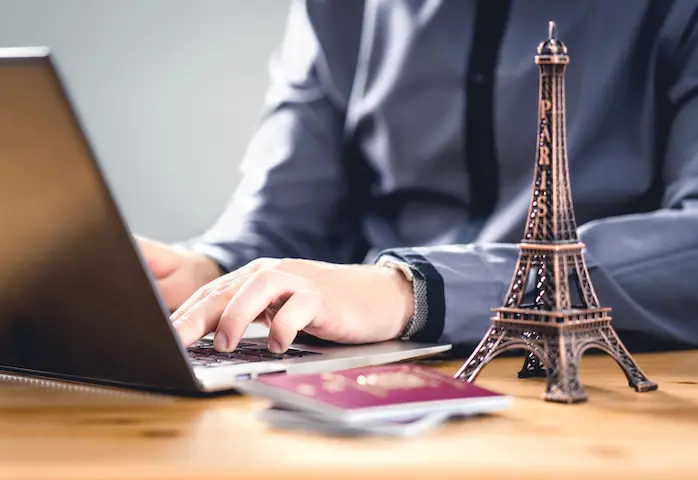 xpatrié consultant un projet d’investissement locatif à Paris sur son ordinateur depuis l’étranger