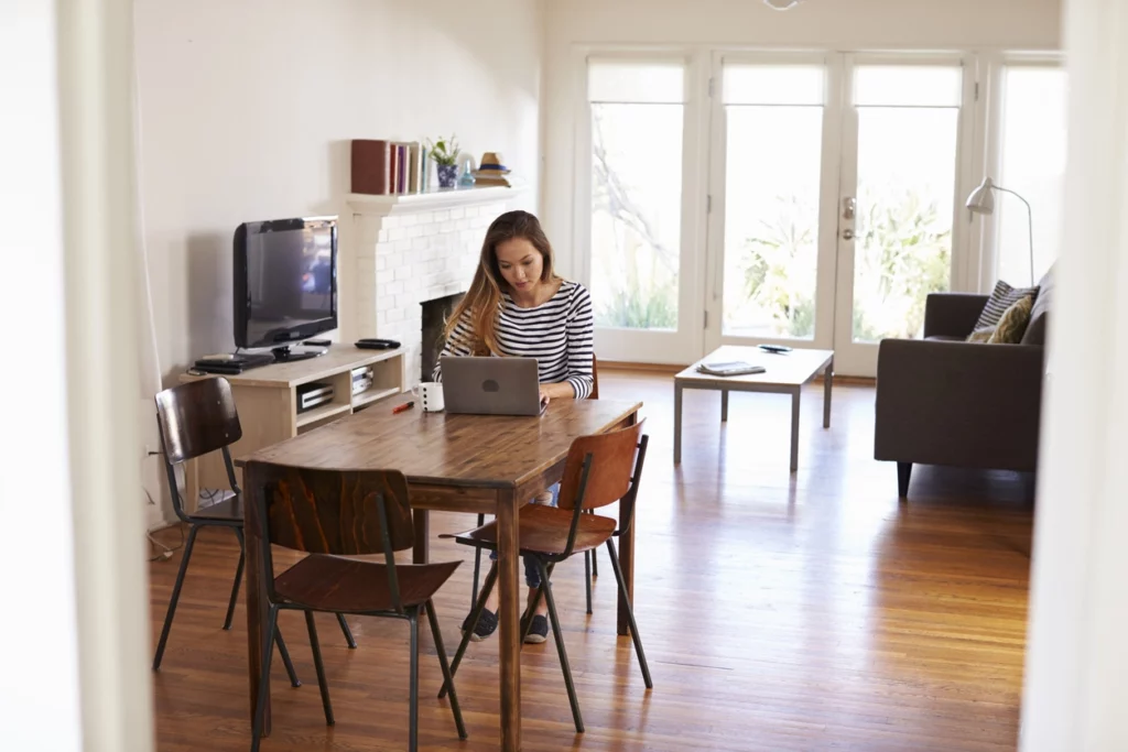 Une femme expatriée qui scrute les infos des agences immobilières en France pour trouver la ville étudiante idéale pour l'investissement locatif.